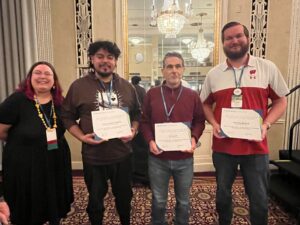 Four Universities of Wisconsin colleagues standing and displaying three awards at the NACADA Region 5 and 6 conference in March 2024 in Milwaukee 