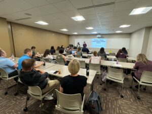 Four Universities of Wisconsin colleagues seated or standing at the NACADA Region 5 and 6 conference in March 2024 in Milwaukee 