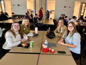 Four Universities of Wisconsin colleagues standing and displaying three awards at the NACADA Region 5 and 6 conference in March 2024 in Milwaukee 