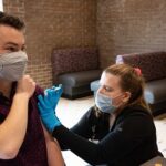 Photo of UW-Stevens Point student Nicholas Tierman receiving his COVID-19 vaccine from Hanna Christensen, one of several UWSP nursing students who are assisting with COVID-19 care and vaccination this spring.