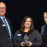 Photo of Beth Hein, center, executive director of Educational Pathways and Outreach, and Chancellor Katherine Frank accepting UW-Stout’s award from Momentum West’s Steve Jahn. / UW-Stout