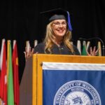 Photo of UW-Stout alumna Shelly Ibach, a 1981 graduate and now CEO of Sleep Number, speaking during commencement. / UW-Stout