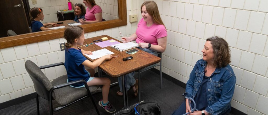 Photo of Blugold psychology graduate student Bryn Hermanson of Berlin working with an elementary school student under the supervision of Dr. Melissa Coolong-Chaffin, professor of psychology and co-director of the Academic Intervention Clinic.