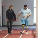 Photo of Walter Van Roo, of La Crosse, walking around the UWL Fieldhouse track with physical therapy student Casey Breunig, a volunteer for the LEAP program. Breunig was hooked after his first session assisting amputees with exercise plans. “This program shows there is a real need for the degree we are pursuing,” says Breunig.
