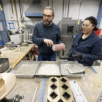 Photo of Konstantin Sobolev, UWM professor of civil engineering, and doctoral student Meraly Lopez Morales looking over concrete samples made with various added materials. A new NSF-funded research center in the College of Engineering & Applied Science will research high-performance concrete and greener methods of making concrete so that industry can bring discoveries into use. (UWM Photo/Troye Fox)
