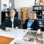 Photo of undergraduate researcher Spencer Smolen and mentor Carolyn Esswein from the School of Architecture and Urban Planning discussing their work to make school playgrounds safer and better for play and learning while also improving stormwater management.