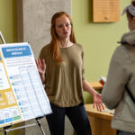 Photo of former UW-River Falls student CJ Sycks speaks with an onlooker during an event in 2022 at the university at which conservation and environmental planning students solicited ideas about planning issues facing the city of River Falls. The Universities of Wisconsin Board of Regents has approved starting a new undergraduate community and environmental planning degree at UW-River Falls that will develop skills specific to urban planning. UWRF file photo.