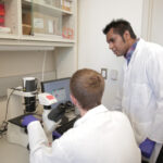 Photo of Krishanu Saha, right, working in a lab at the Wisconsin Institute for Discovery. Submitted photo