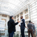 Photo of Ethan Gu, a PhD student in computer science at Marquette University, talking with Onochie Fan-Osuala, an associate professor at UW-Whitewater, at a Northwestern Mutual Data Science Institute event. (Jaclyn Tyler photo)