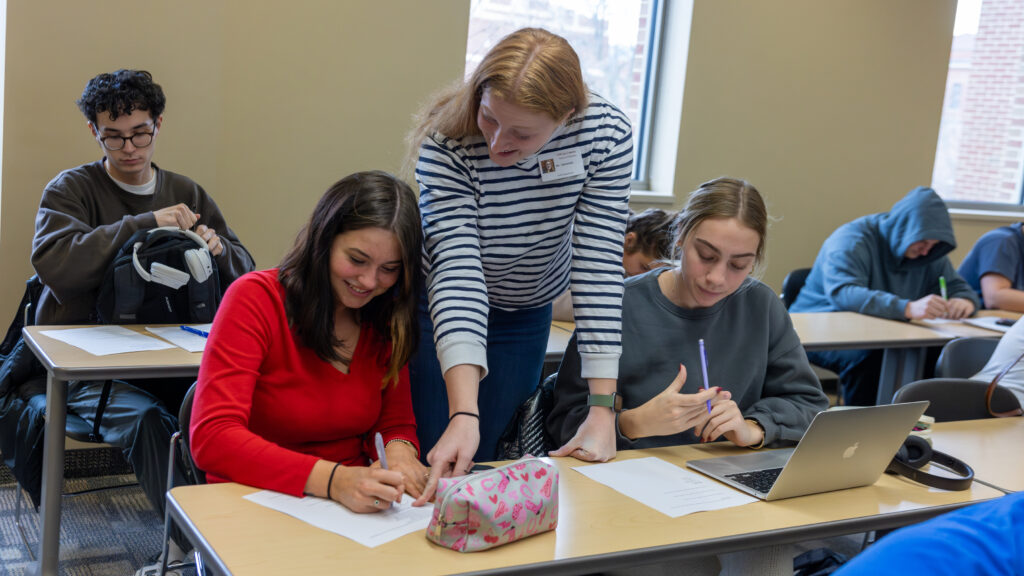 Photo of Caitlin Herminath (center), a senior majoring in mathematics education, who is one of a handful of students who have benefitted from UWL's new Math Education Teaching Assistant Program. The program allows aspiring educators to gain experience co-leading a general education math course that closely mirrors what they will see in an actual high school.