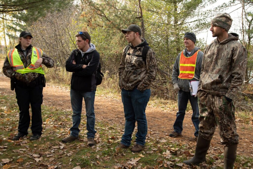 Photo of Associate Professor Mike Rader (second from right) who uses strong relationships with the Wisconsin warden force and hands on experience to prepare students for careers in conservation law enforcement.