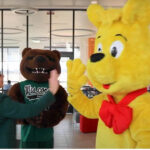 Photo of UW-Parkside Chancellor Lynn Akey with mascot Ranger D. Bear and Haribo mascot Goldbear during "Mascots on Main" video