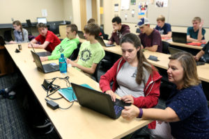 Photo of Professor Diane Christie, right, helping students in a Computer Science I class in September at UW-Stout, which has been named a national Center of Academic Excellence in Cyber Defense.