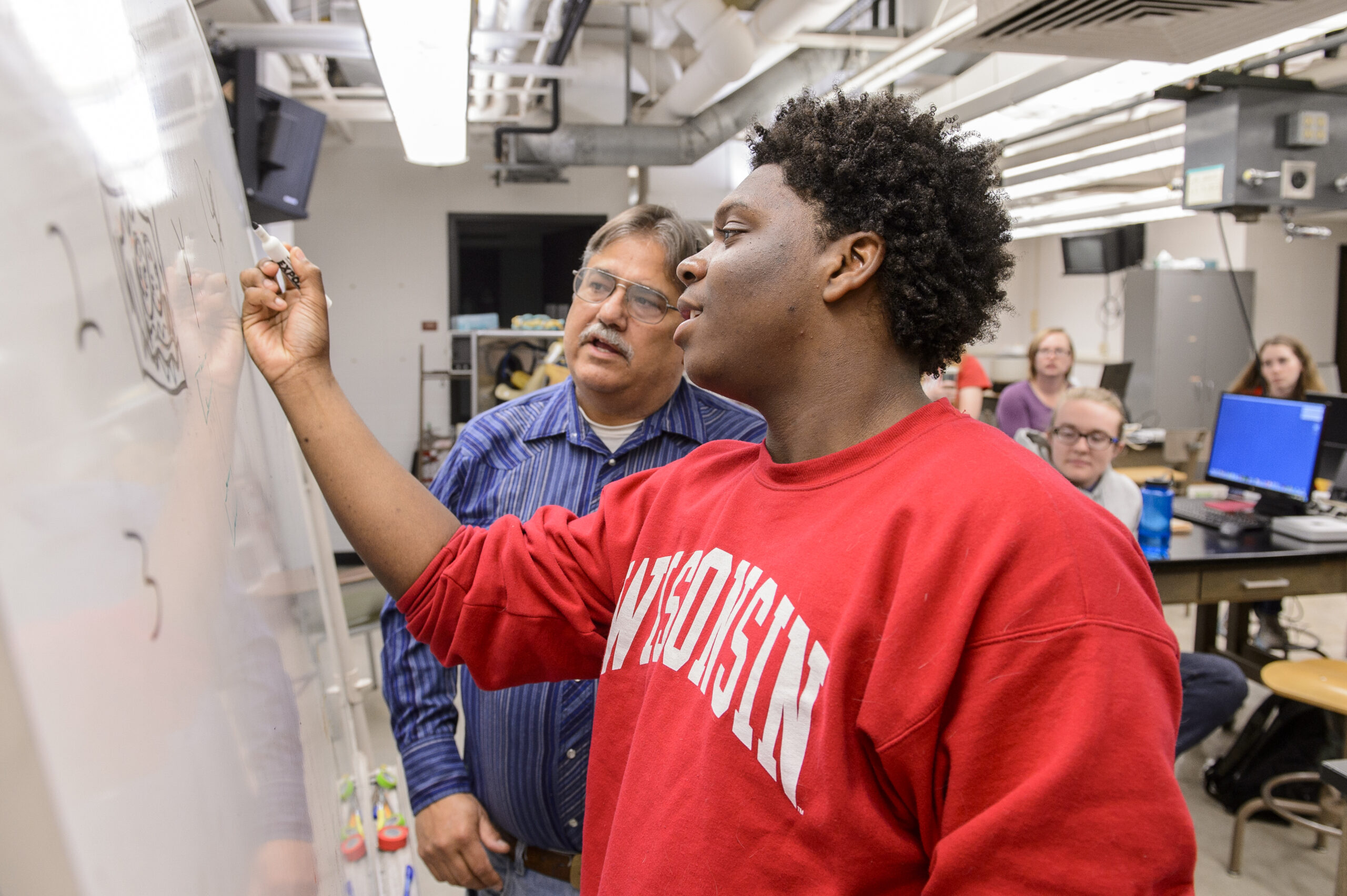 Student being trained by professor in lab space